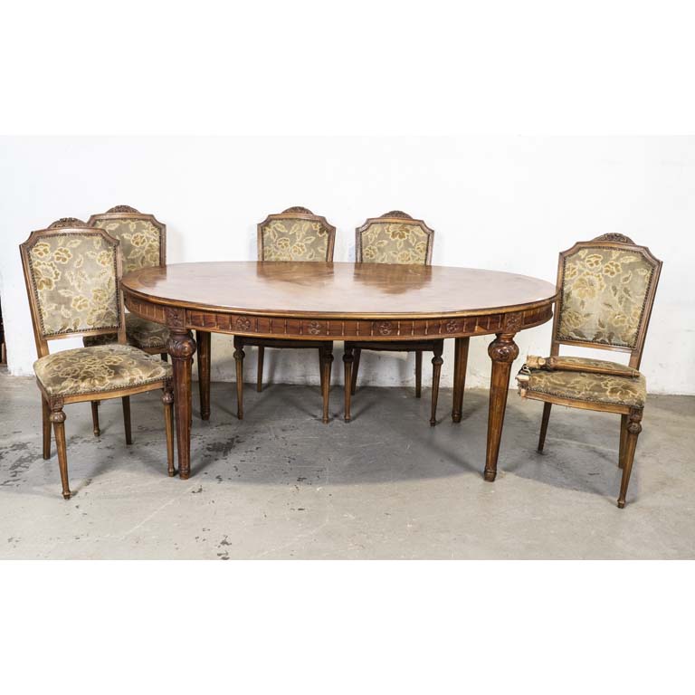 Mesa de comedor oval, estilo Luis XVI y cinco sillas tapizadas en pana labrada. Orificios de polillas en mesa y sillas. Mesa con avería en el enchapado. Silla flojas, una pata con avería y tapizado con desgaste. - Medidas: 189x111x79cm