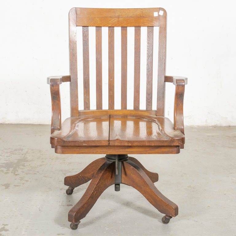Antiguo sillón de oficina: en roble, rodante y con asiento giratorio. Almohadón en el asiento. Asiento flojo y con abertura en la madera. Respaldo desencolado y detalles en el lustre. - Medidas: 62 x 49 x 93cm