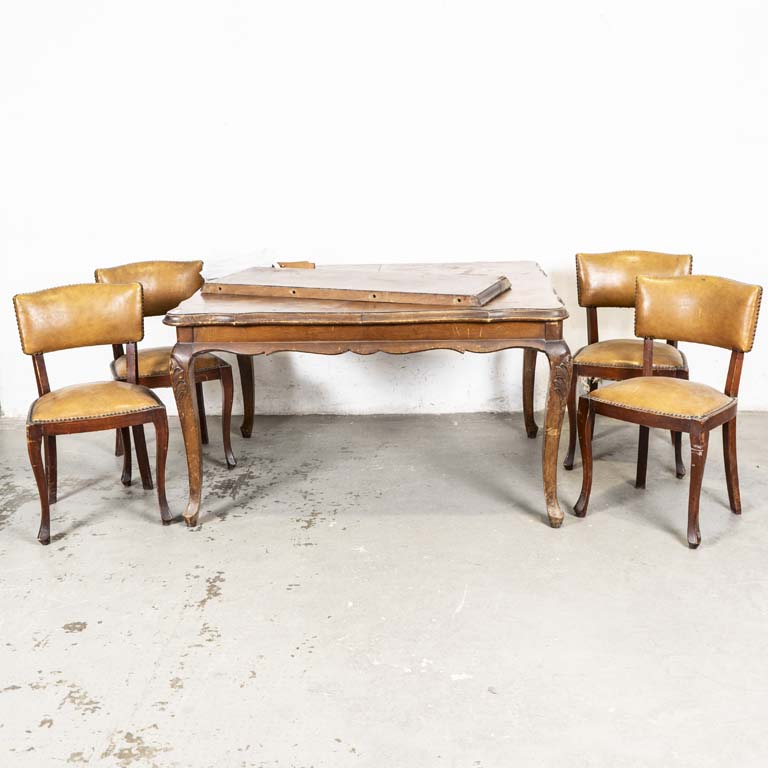 Mesa de comedor francesa, con tabla y cuatro sillas tapizadas en neosky. Tapa de la mesa suelta. Tapa manchada con detalles en el lustre y en los tapizados. - Medidas: 140 x 113 x 80cm
