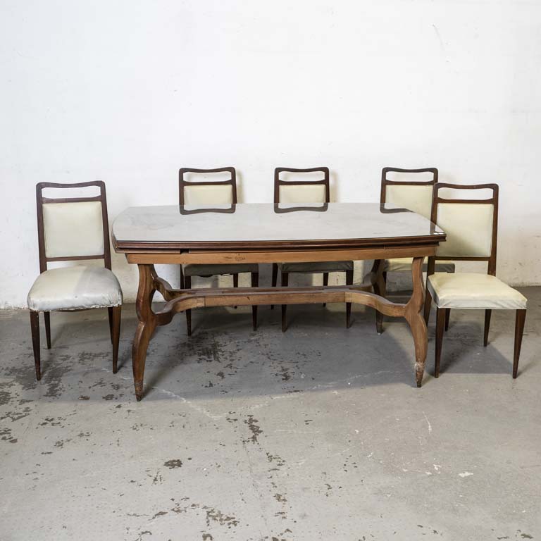 Mesa de comedor americana tiré, con cinco sillas tapizadas. Mesa con detalles en el lustre. Sillas para retapizar, con averías en el tapizado y en el lustre. - Medidas: 161x87x80cm