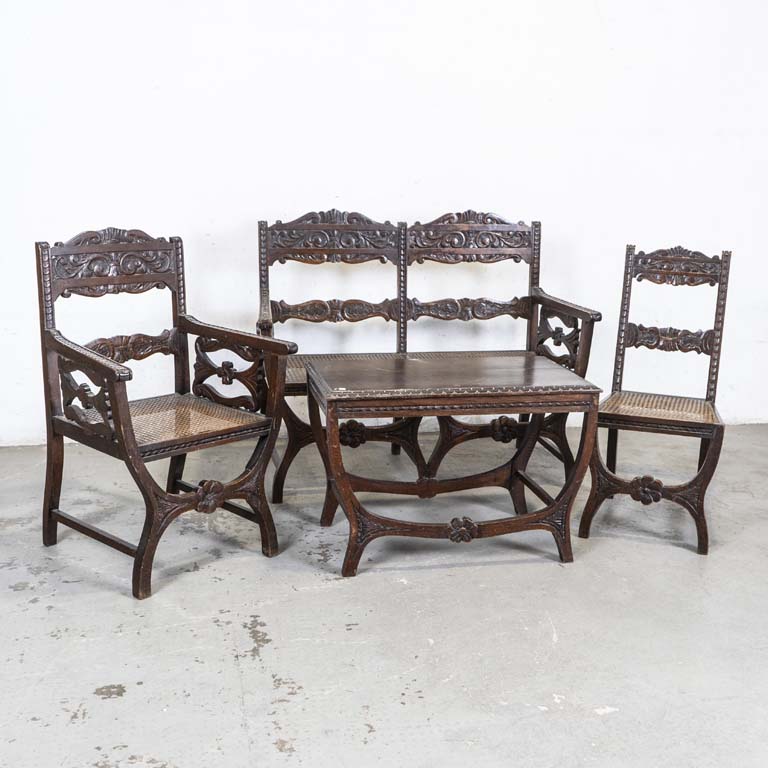 Cuatro piezas de sala venecianas en roble, talladas y con asientos esterillados. Mesita, sofá de dos cuerpos, butaca y silla. Asientos hundidos, detalles en el lustre. - Medidas: 119x53x97cm