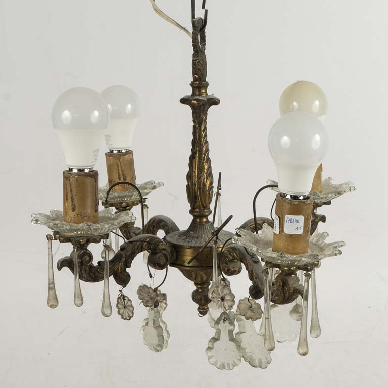 Araña de bronce y cristal con 4 luces. Con detalles en los caireles. No se probó, puede tener faltantes y detalles. El lote se vende a la vista, sin reclamos. - Medidas: 42x35cm