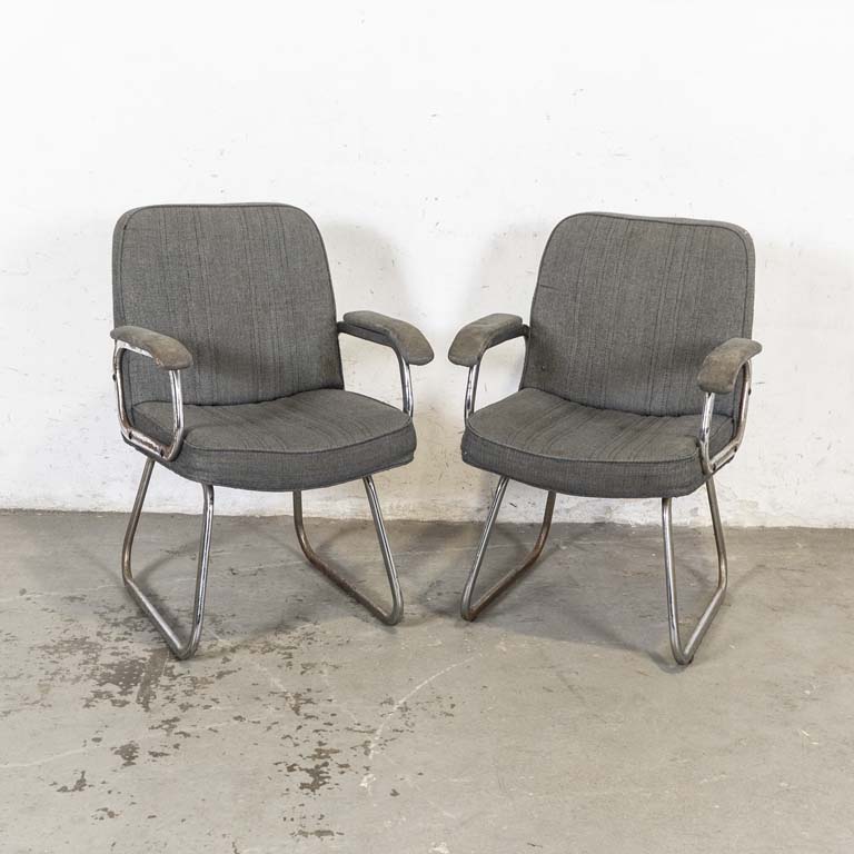 Par de sillas de oficina fijas, patas cromadas, con: asientos, respaldos y reposabrazos tapizados. Para restaurar: cromados saltados y con óxido. Tapizados manchados, con averías y desgaste. - Medidas: 58 x 56 x 83cm