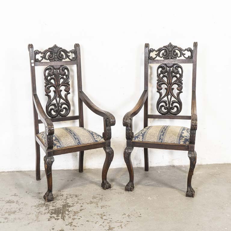 Par de sillones reina Ana, en roble. Respaldos altos tallados y asientos tapizados. Reposabrazos desencolados, detalles en la madera y para lustrar. Tapizados con desgaste (para retapizar). - Medidas: 56x63x127cm
