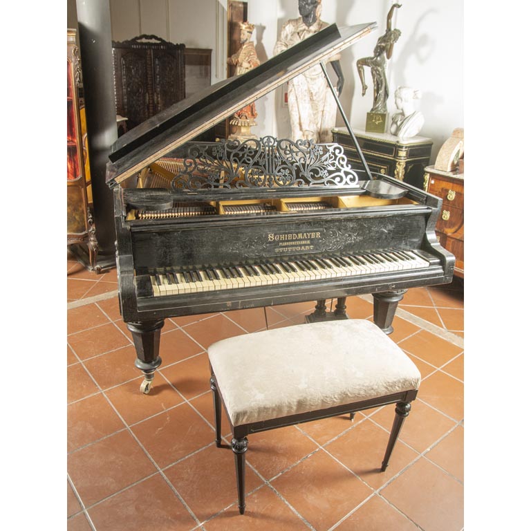 Piano de ¼ cola Schiedmayer – Stuttgart, caja en madera ebonizada, con detalles en el lustre, con banqueta - Medidas: 172x151x 00 cm, largo total 192cm