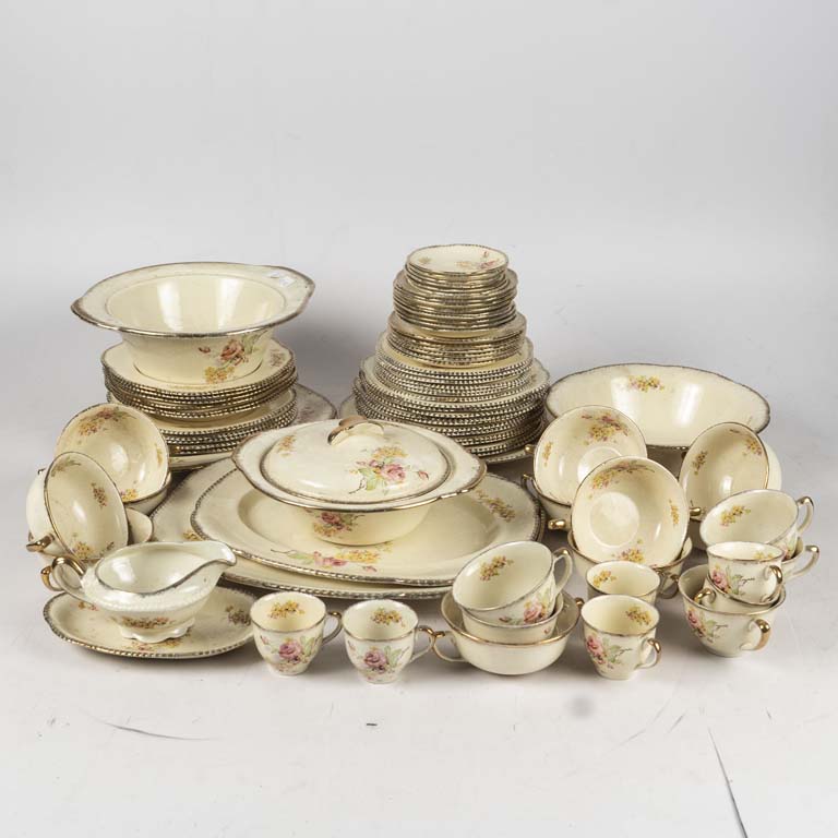 78 Piezas de loza inglesa Woods Ivory Ware, decorado flores con borde dorado. Un plato hondo y 6 llanos con cascadura, 2 platos de consomé con cascadura, 2 platos de lunch con cascadura, un plato de café con cascadura. Piezas manchadas y con borde dorado gastado. Falta tapa de sopera. - Medidas: Taza de té: 9.5x7cm