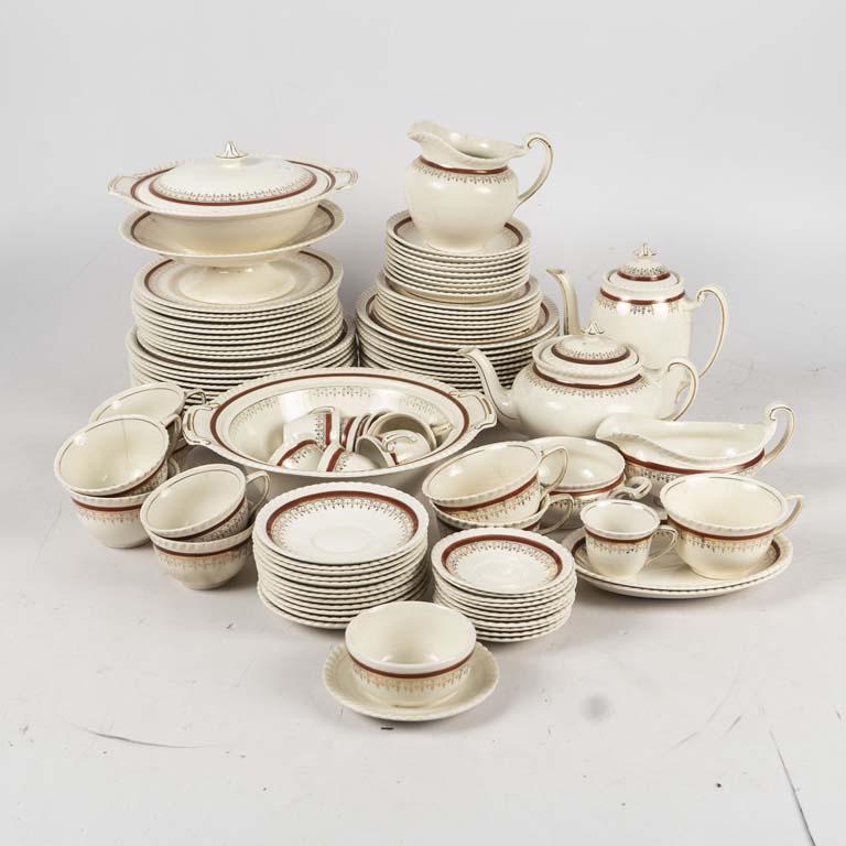100 piezas de loza inglesa Johnson bros , fondo beige con guarda dorada y bordo, bordes lobulados. 5 platos con cascaduras, taza con fisura, piezas craqueladas y alguna pieza manchada. Faltan dos tapas. - Medidas: Taza: 10x6cm