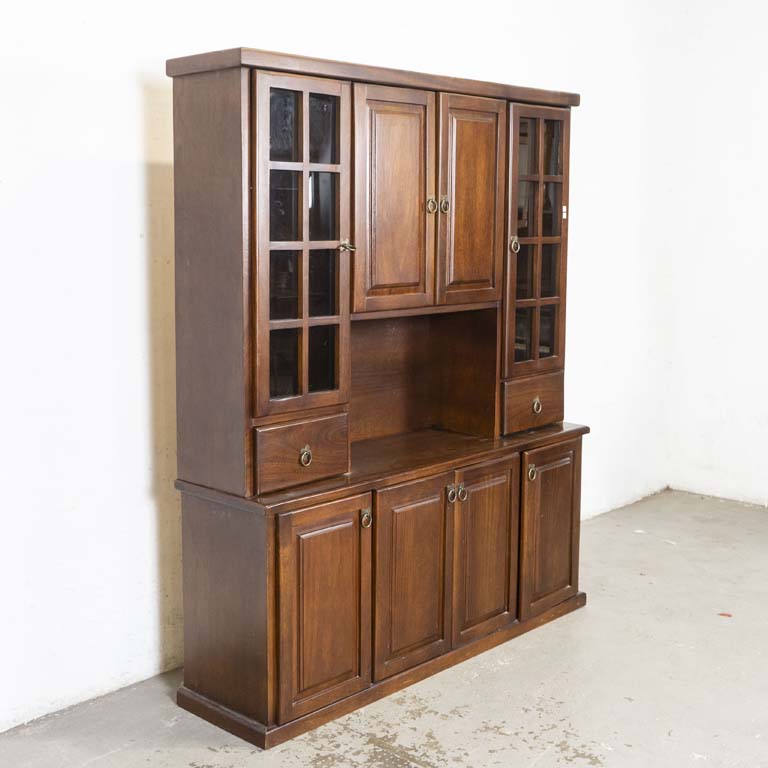 Aparador cristalero (en dos partes), en cerejeira, con: ocho puertas, dos cajones y estante central. Dos puertas laterales con frentes vidriados y estantes de vidrio interiores. Detalles en el lustre. - Medidas: 160 x 41 x 193cm