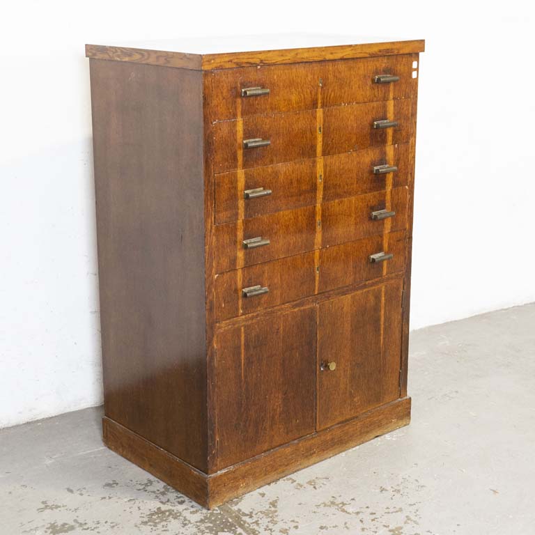 Cajonero art decó enchapado en roble, con cinco cajones y dos puertas (tiradores de bronce). Polillas en la trasera, averías en el enchapado y detalles en el lustre. - Medidas: 88x56x130cm