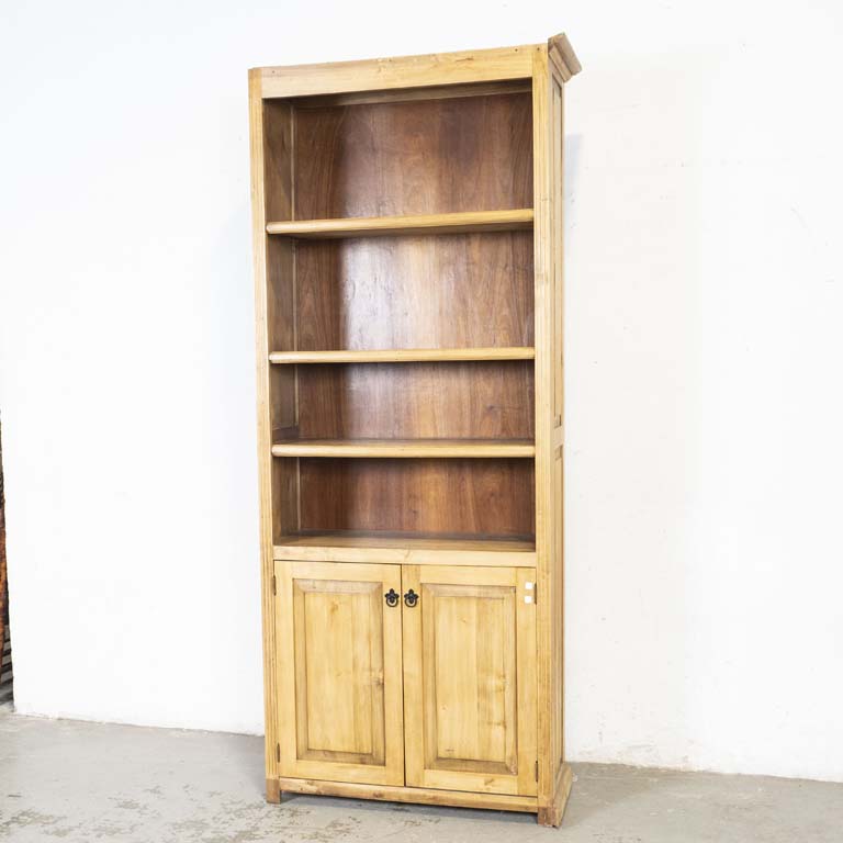 Estante biblioteca con dos puertas. Falta la moldura de terminación superior, lateral sin terminación y falta zócalo. Con varios detalles en la madera. - Medidas: 91 x 35 x 230cm