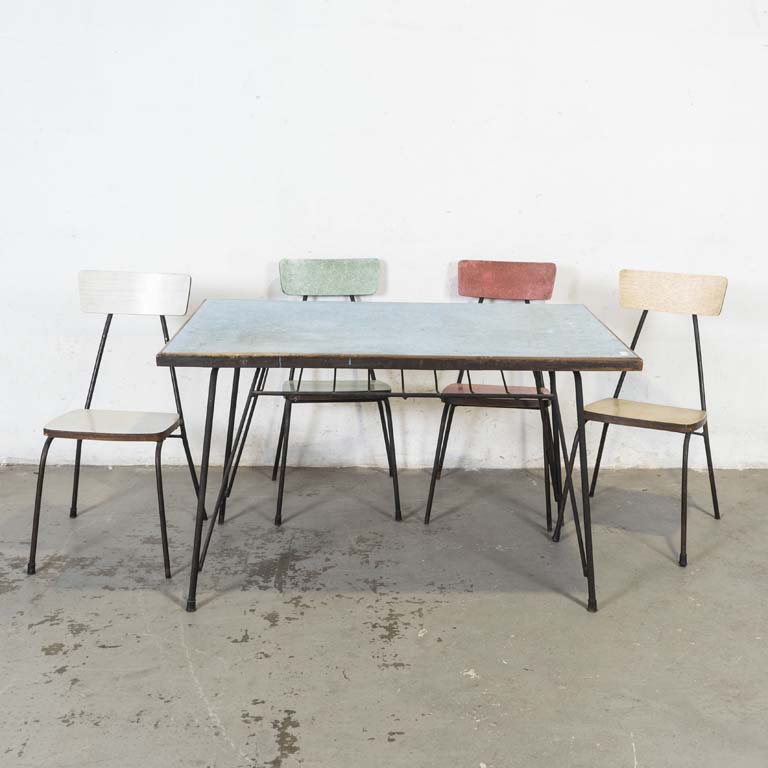 Mesa de comedor con cuatro sillas. Mesa con tapa de cármica y base de hierro. Sillas con asientos y respaldos de cármica y estructuras metálicas. Cármicas rayadas y con averías. Detalles en la pintura del metal. - Medidas: 127x79x77cm