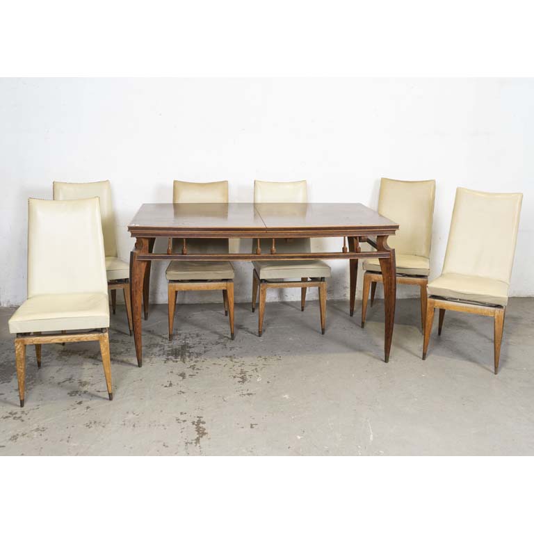 Mesa de comedor con tabla y seis sillas tapizadas en cuerina. Tapizados diferentes con averías y detalles. Faltan regatones. Detalles en el lustre y en la madera. - Medidas: 150 x 92 x 83cm