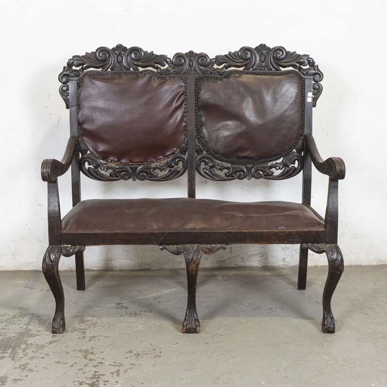 Sofá de dos cuerpos tallado estilo renacimiento, respaldo y asiento tapizado en cuerina. Tapizado hundido y con detalles. Detalles en la madera y en el lustre. - Medidas: 120 x 60 x 117cm