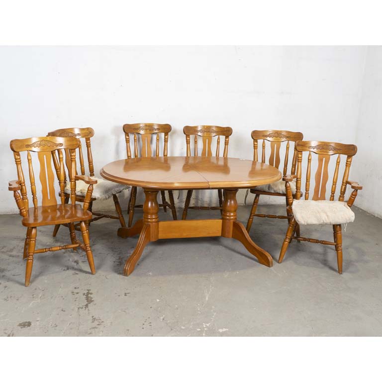 Mesa de comedor oval, con tabla interior, cuatro sillas y dos butacas, estilo Windsor (con respaldos tallados). Almohadones en los asientos (con desgaste). Detalles en el lustre. - Medidas: 145 x 104 x 73cm