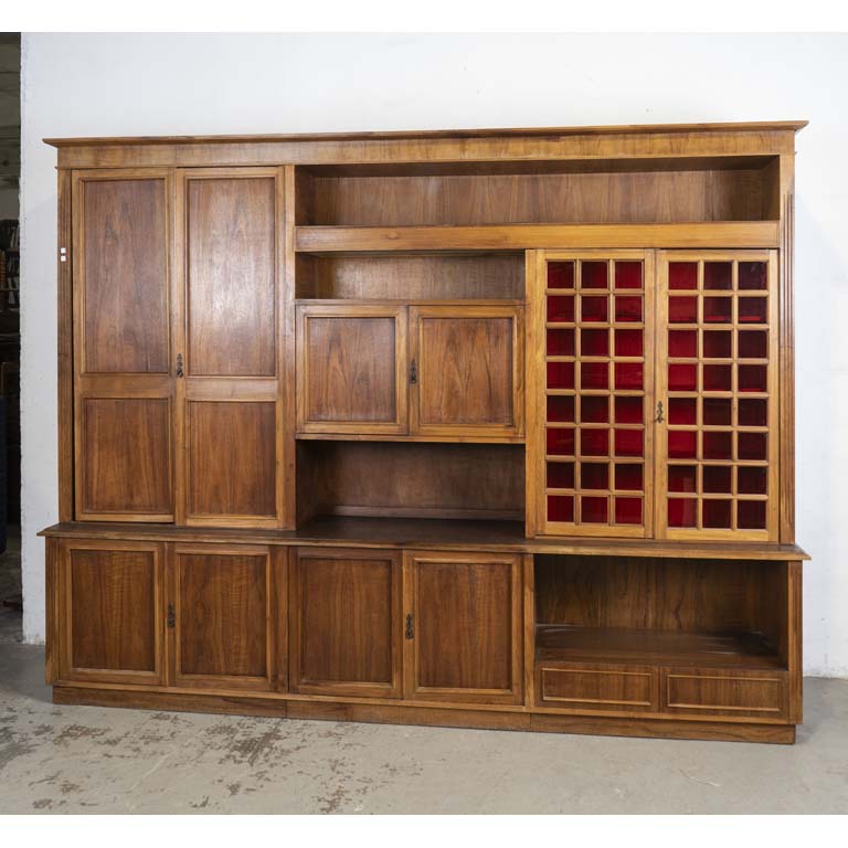 Modular con: 10 puertas (dos con frentes de acrilicos rojos), estantes y dos cajones (uno cubiertero). Mueble presentado para la foto, desajustado y con piezas sueltas. Bar en el sector central, sector izquierdo con estantes de vidrio y luz superior. Detalles en el lustre. - Medidas: 286x49x222cm