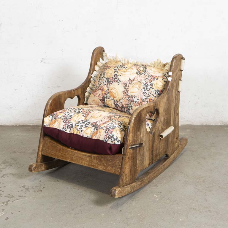 Sillón mecedora bajo, laterales de madera con almohadones. Falta traba del asiento. Detalles en el lustre, cinchas de tela con desgaste y almohadones para limpiar. - Medidas: 60x62x70cm