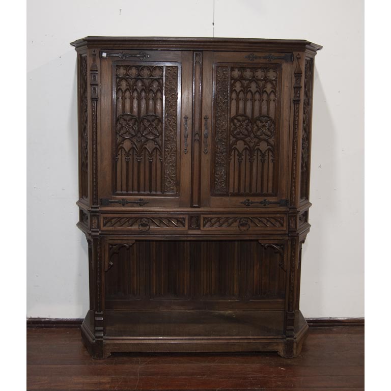 Bargueño Español en cedro tallado, 2 cajones y 2 puertas, herrajes de hierro, interior con espejos y estantes de vidrio, faltan 2 soportes para los estantes. -Medidas: 145x43x180cm